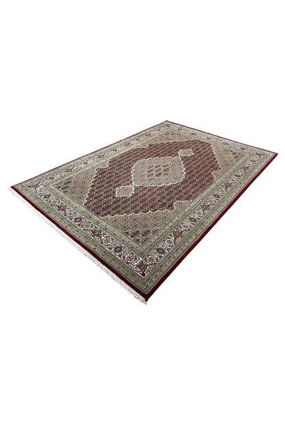 Indo Tabriz rug in diagonal view, central patterned area with an encircling border