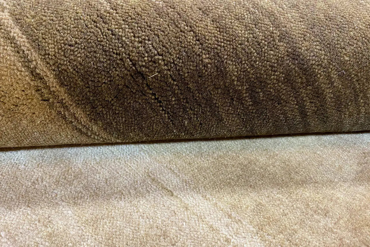 Gabbeh rug close-up of the pile texture and seam edge in ochre and brown