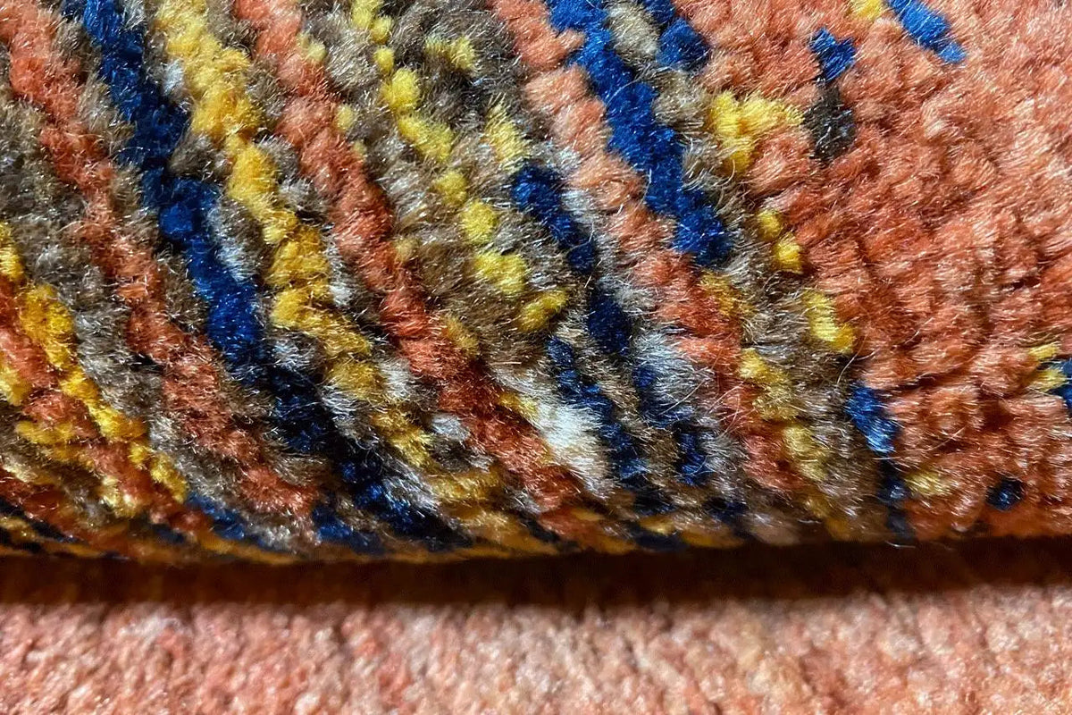 Close-up of a Gabbeh rug: multicolored stripes in blue, yellow, and red on brown