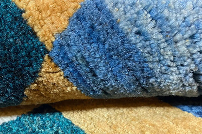 Gabbeh rug “Lori” close-up: blue-gray pile with gold-colored and beige areas