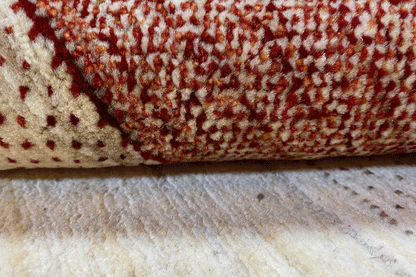 Gabbeh rug detail of the border with burgundy dots on a cream-colored background