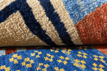 Gabbeh rug “Lori” pattern detail: blue and beige-toned ornaments with red accents