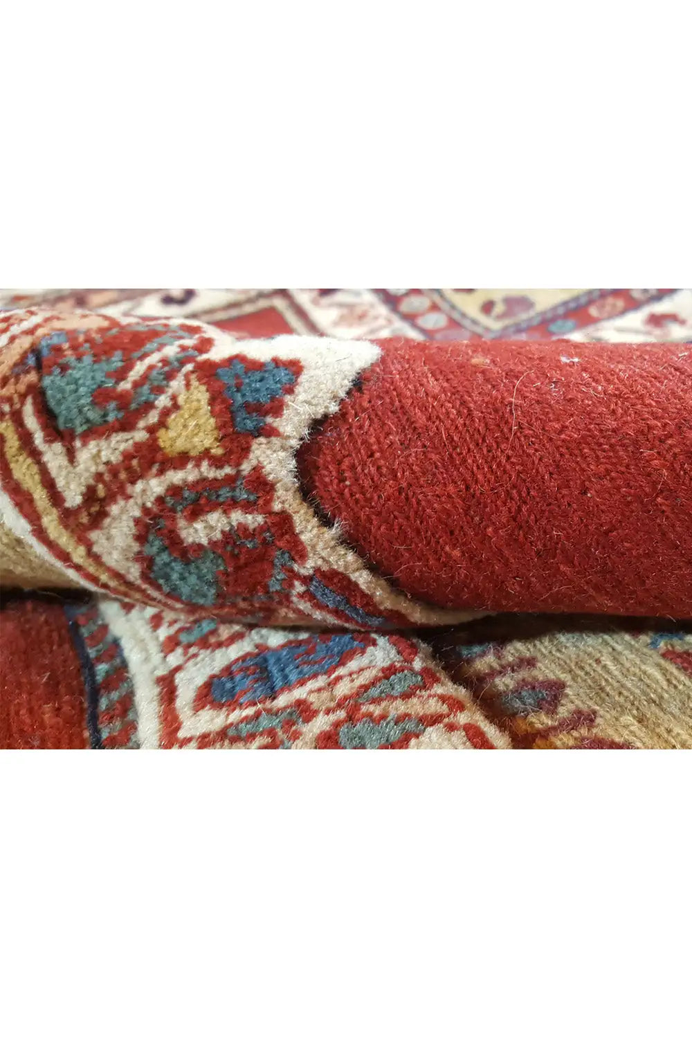 Carpet detail: red pile with beige and blue patterns along the edge