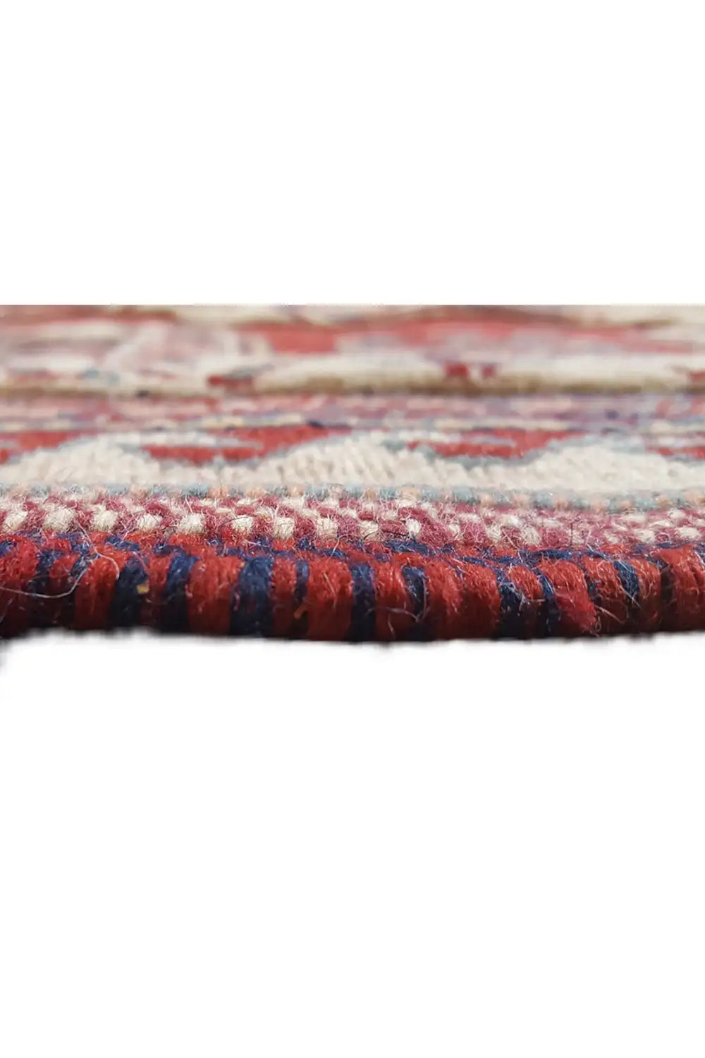 Carpet edge in detail: red-blue patterns, dense woven surface, short fringes