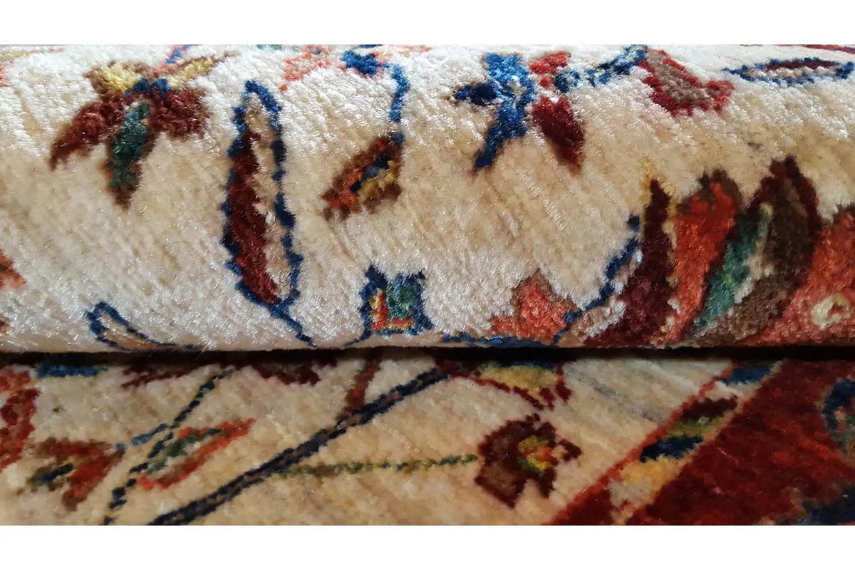 Carpet detail: cream-colored pile with multicolored ornamental lines and floral motifs