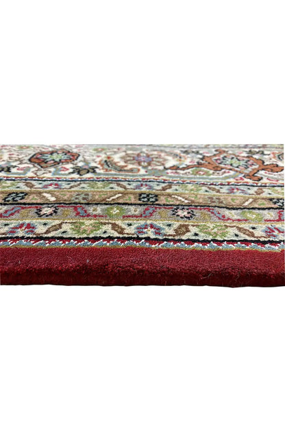 Indo Täbriz rug detail: colorful border, short fringes along the edge, textured surface