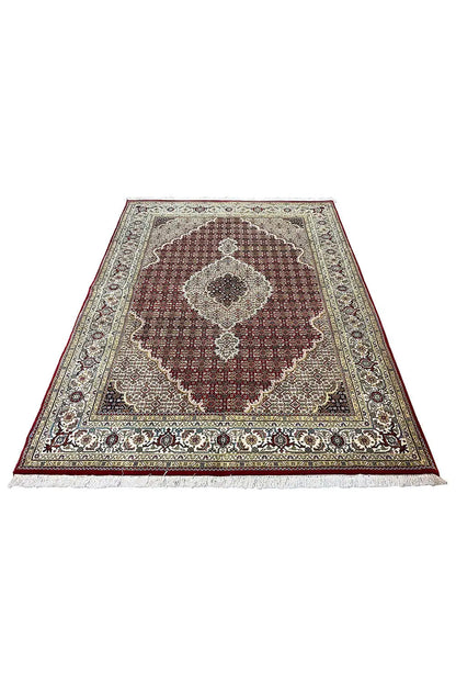 Oriental rug with a round medallion pattern in burgundy, beige, and dark brown
