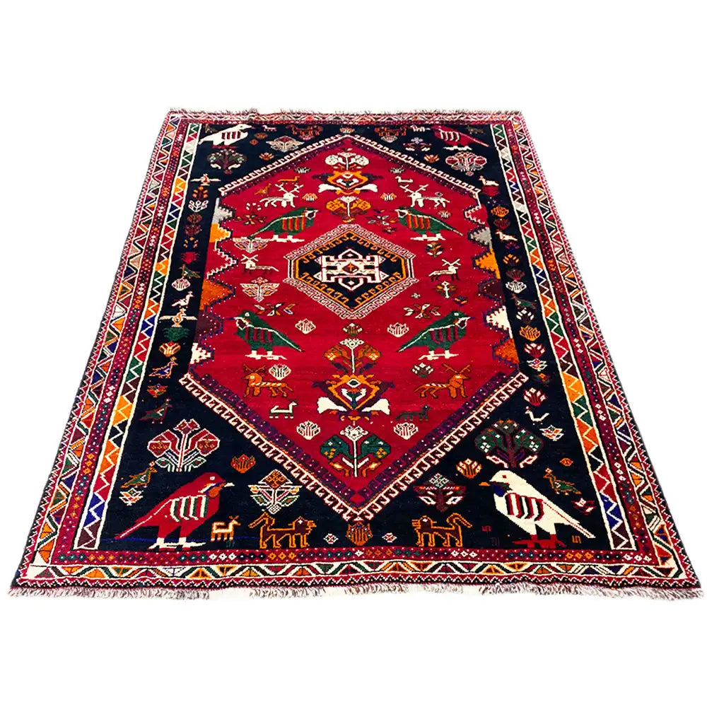 Shiraz carpet 255x170 cm, red with a dark blue border and geometric decorative trim.