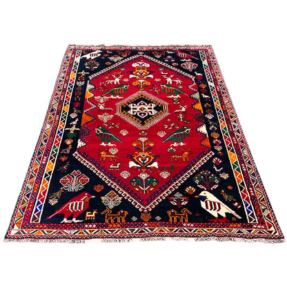 Shiraz carpet 255x170 cm, red with a dark blue border and geometric decorative trim.