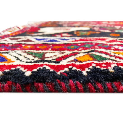 Shiraz rug detail: frayed edges, a red and dark blue pattern, and decorative lines.