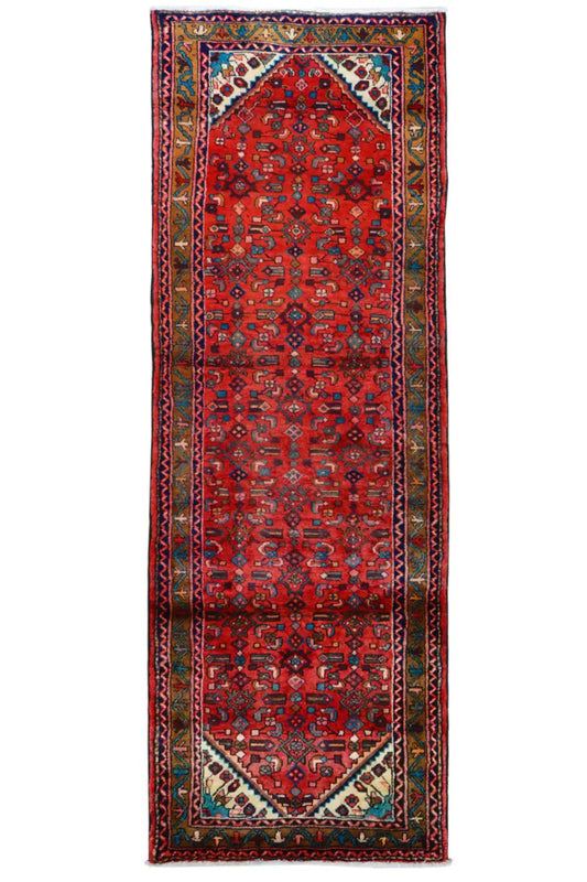 Rectangular Hamadan rug with a red background, border framing, and multicolored ornaments.