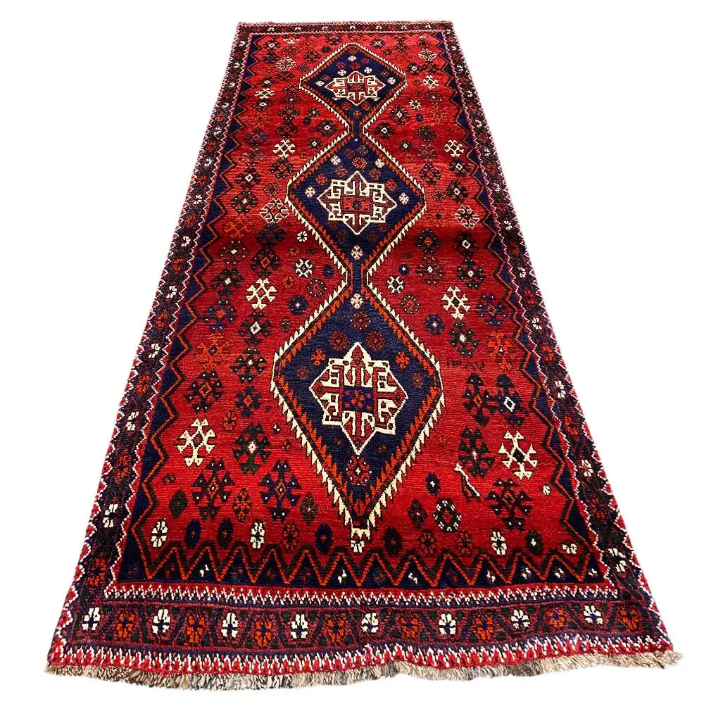 Red runner with blue-bordered medallions, a dark border, and fringe along the bottom
