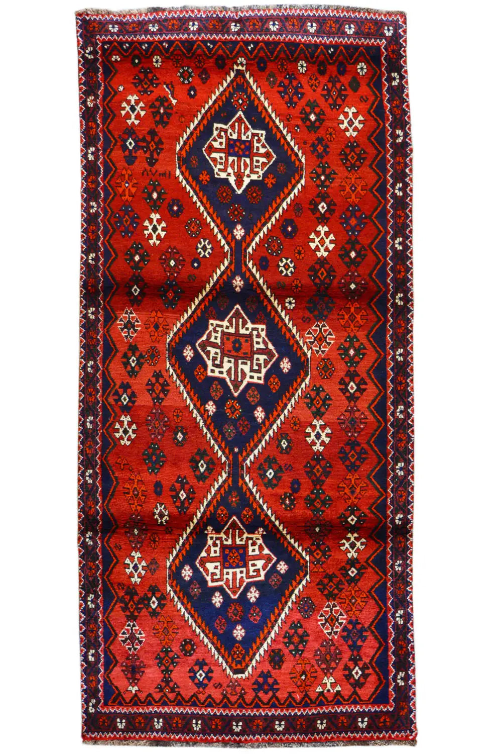 Rectangular red runner with a blue central ornament and zigzag border