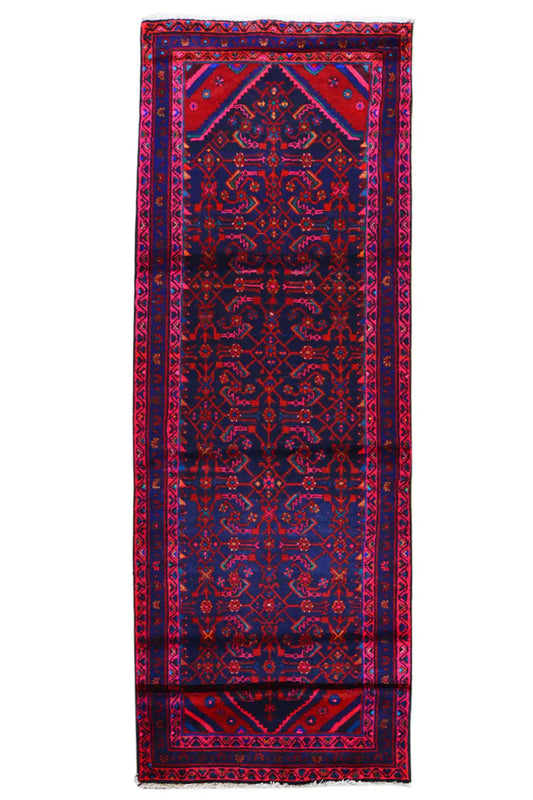 Portrait-oriented Oriental rug runner with a central medallion and blue/pink border