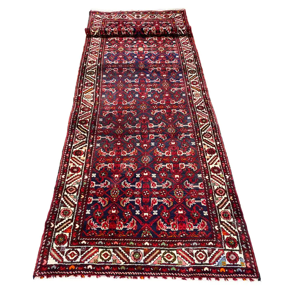 Red-and-blue runner with a hemmed edge and dense ornamental pattern in the central area