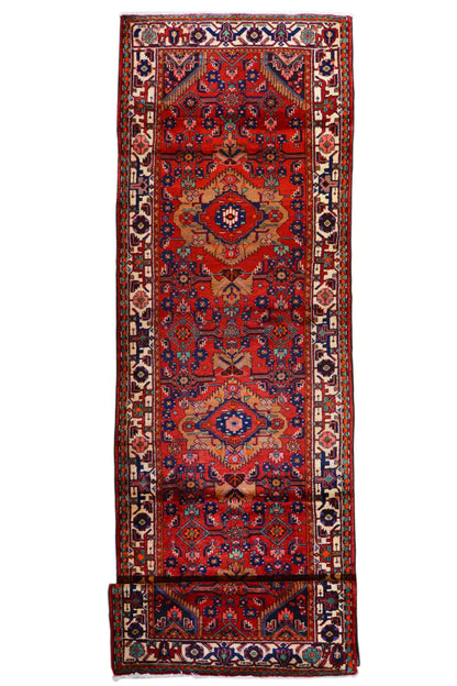 Long Oriental runner: red base pattern, central medallion design and surrounding decorative border