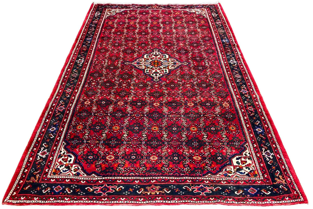 Red Oriental rug with a delicate clover pattern and wide border