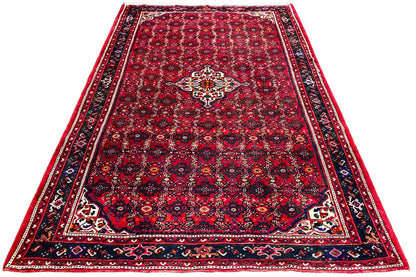 Red Oriental rug with a delicate clover pattern and wide border