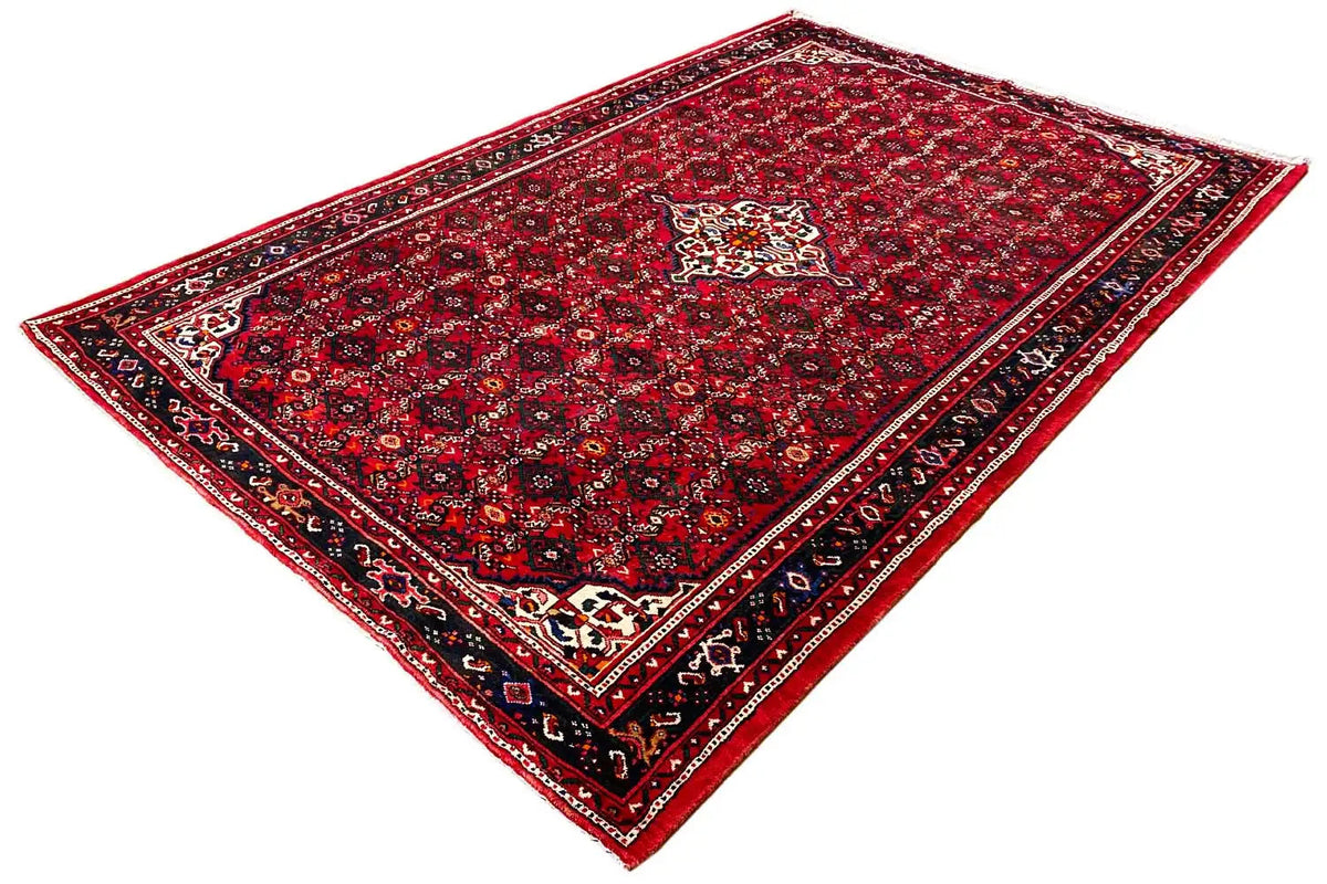 Oriental rug, dark red with a geometric medallion and diagonal view