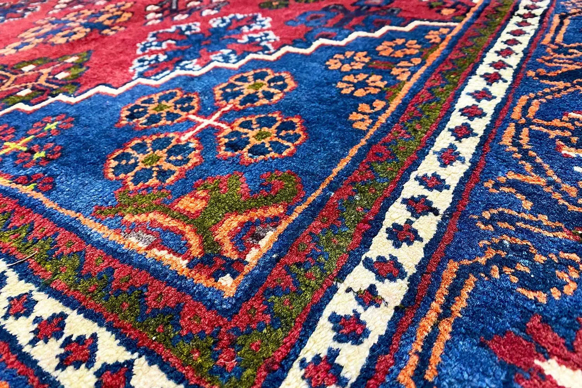 Detail view: Hamadan rug with colorful floral ornaments in blue and red
