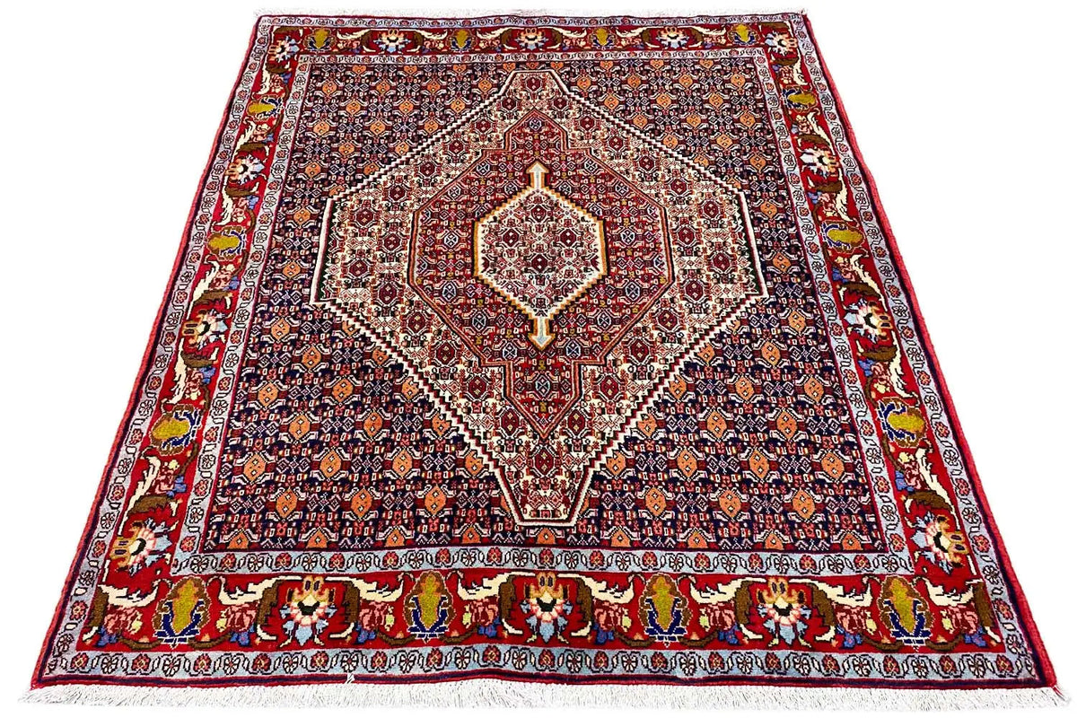 Rectangular Oriental rug with a dark blue patterned field and red border ornamentation