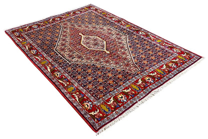 Oriental rug with a wide red border and symmetrical central ornamentation