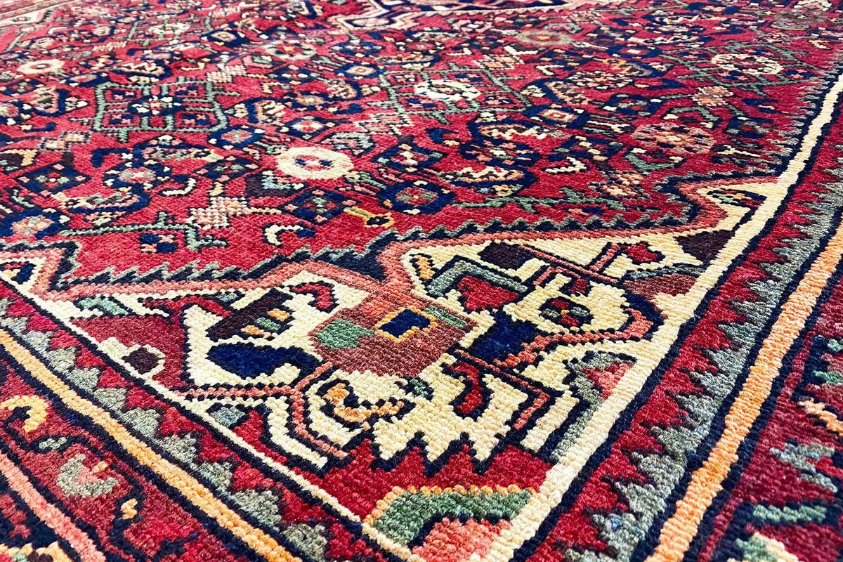 Hamadan rug detail with red, blue, and cream-colored motifs, border, and ornaments