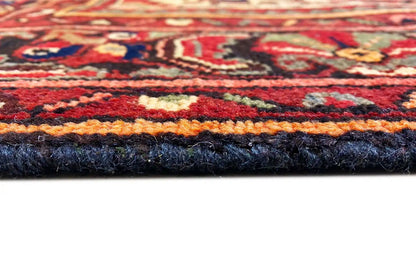 Hamadan rug with a dense pile surface and bound edge, visible finish