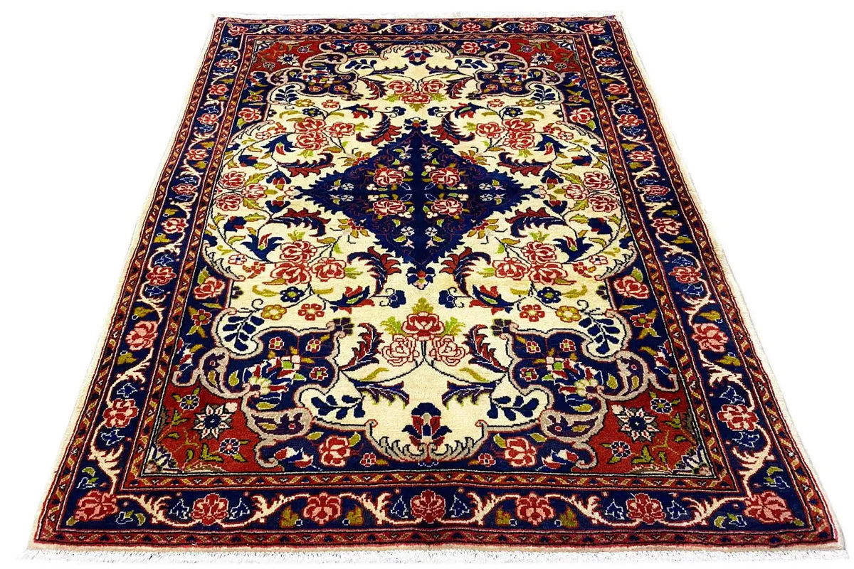 Rug with a large central motif and delicate border pattern in blue, red and cream