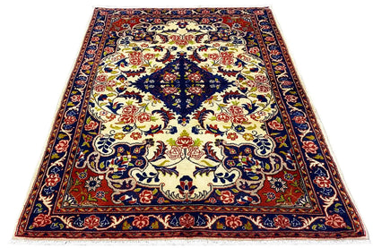 Rug with a large central motif and delicate border pattern in blue, red and cream