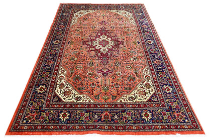 Rectangular Tabriz rug with a red-orange field, dark border, and ornaments