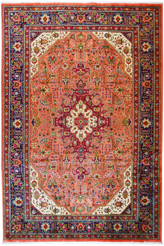 Tabriz rug with an orange-red medallion, dark blue border, and floral patterns