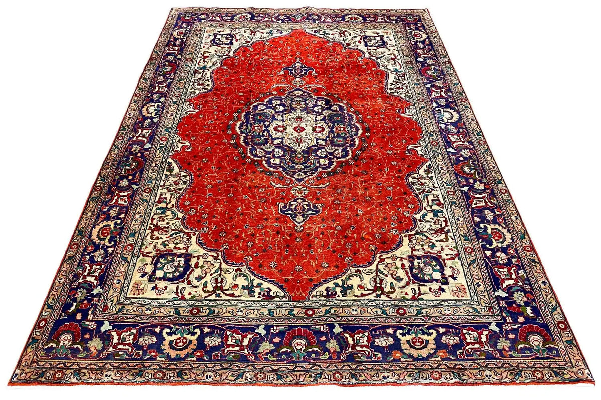 Rectangular Oriental rug with a red field, cream-colored ground, and blue decorative border