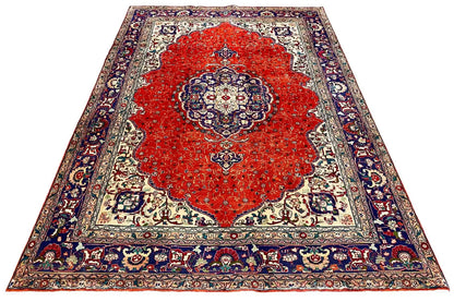 Rectangular Oriental rug with a red field, cream-colored ground, and blue decorative border