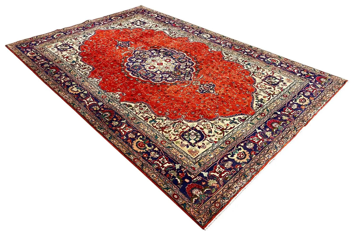 Oriental rug spread out with a red central motif and delicate patterns in the cream-colored field