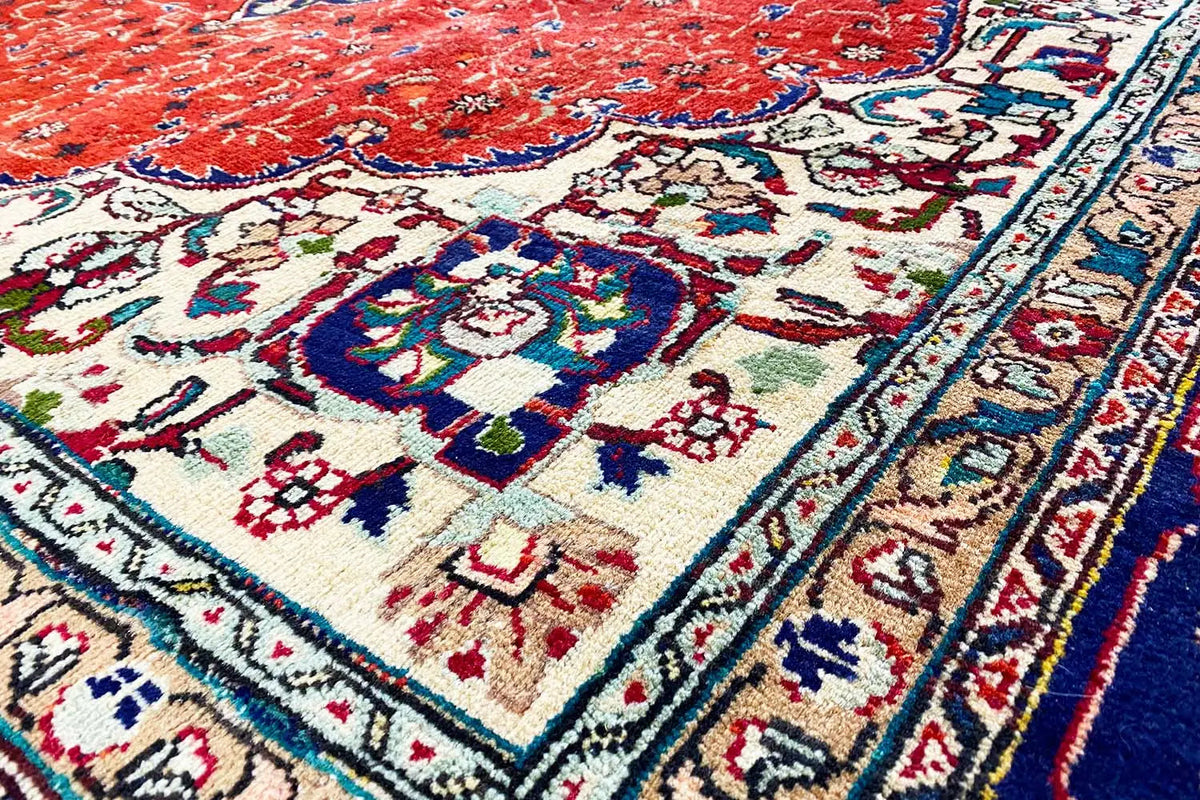 Rug detail: red field with ornaments, cream ground, blue-red decorative border line