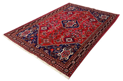 Red rug with dark blue patterned elements and white accents