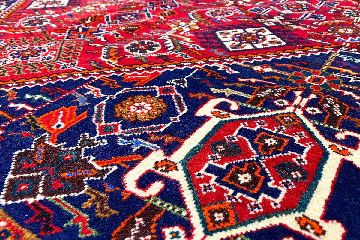 Close-up: red carpet pattern with a blue center and multicolored ornaments