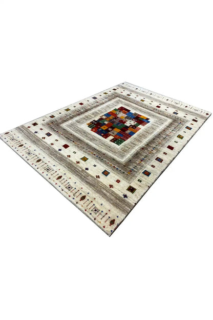 Gabbeh rug (150x102 cm) angled view: cream-colored border around a colorful patchwork center