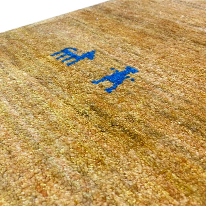 Gabbeh rug, golden yellow with blue patterned figures in the pile, close-up