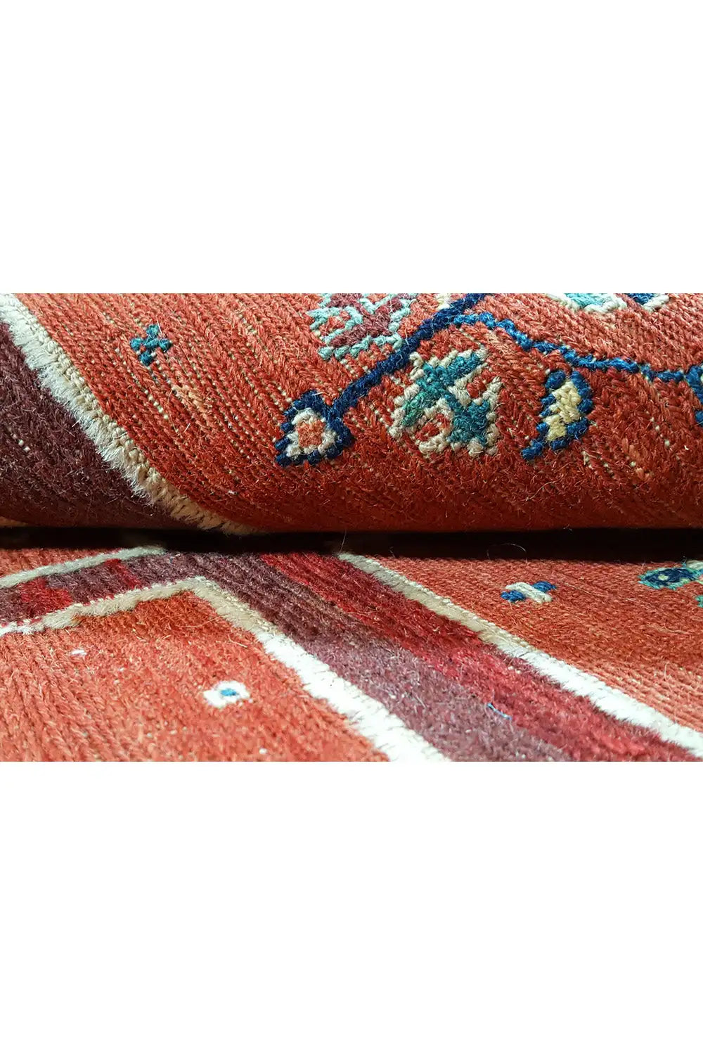Soumak rug: close-up of the woven red pile with blue-decorated motifs.