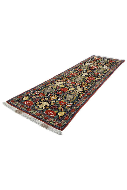 Long-format rug with a diagonal cut, fringes, and a floral pattern in dark blue/red