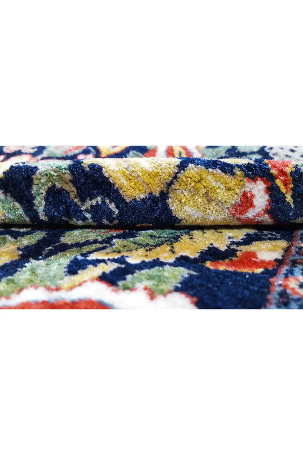 Close-up: Carpet edge with pile and a colorful ornamental pattern in blue, yellow, and red