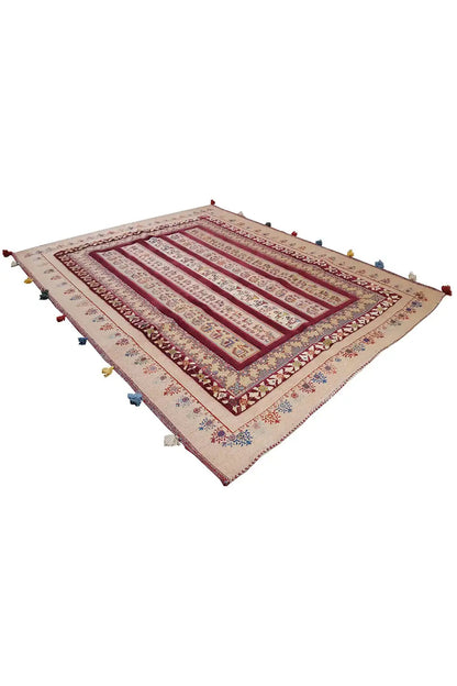Soumak rug with a beige-red pattern and multicolored tassels at the corners, at an angle