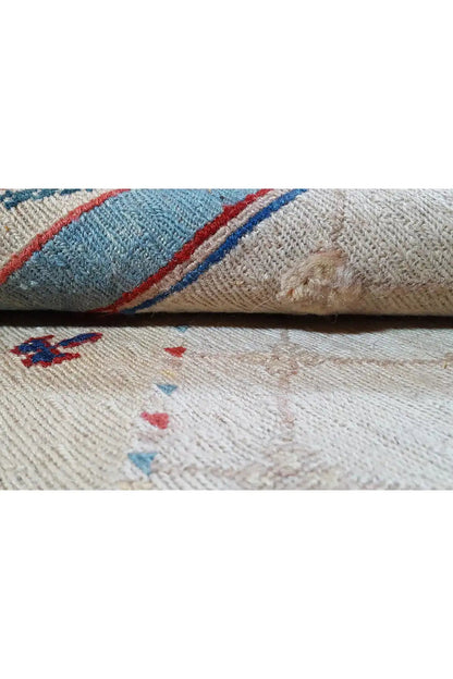 Carpet detail: woven edge with a blue decorative stripe and beige pile