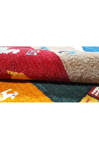 Gabbeh rug detail: red and beige area with a colorful motif and pile