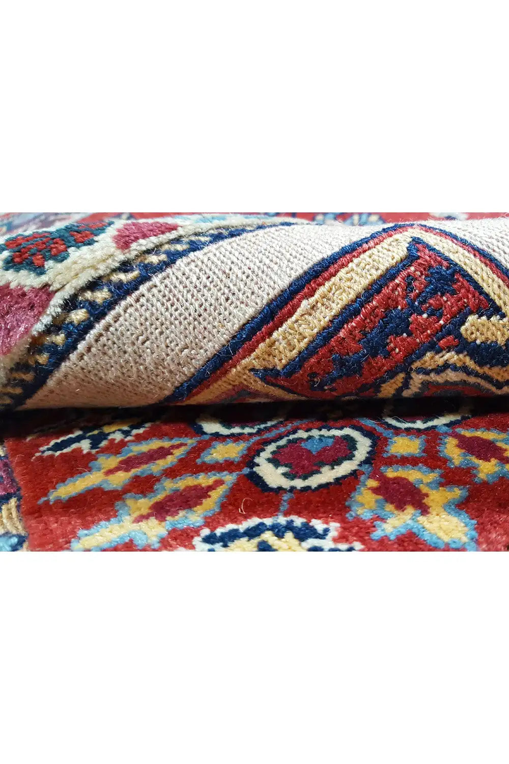Carpet detail: knotted edge with colorful borders on a beige background, fringe.