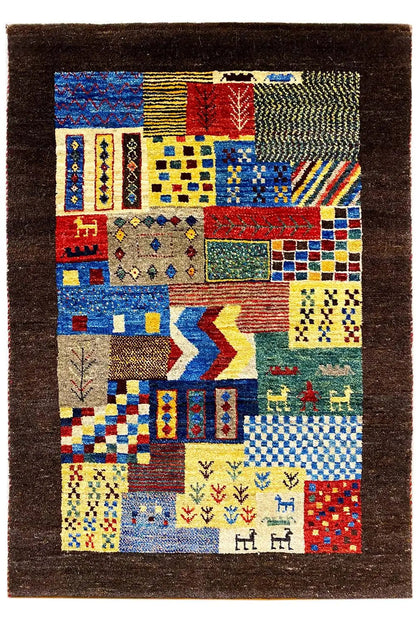 Gabbeh rug with blue-red-yellow patchwork squares and symbolic motifs on a dark brown background