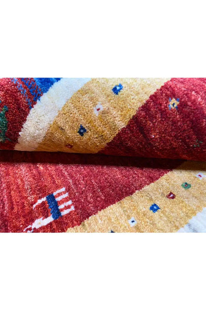 Gabbeh rug (123x80 cm) close-up: red/beige pile, multicolored embroidered motifs