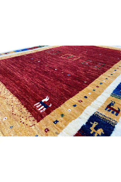 Gabbeh rug (123x80 cm) close-up: red field, beige border, blue-green patterns